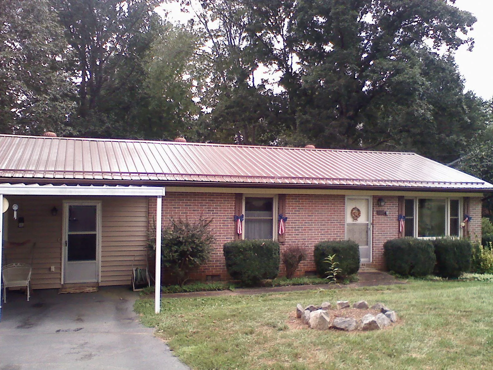 Bronze metal roof and carport on a brick ranch home — Roof Repair work by our crew in Terrell