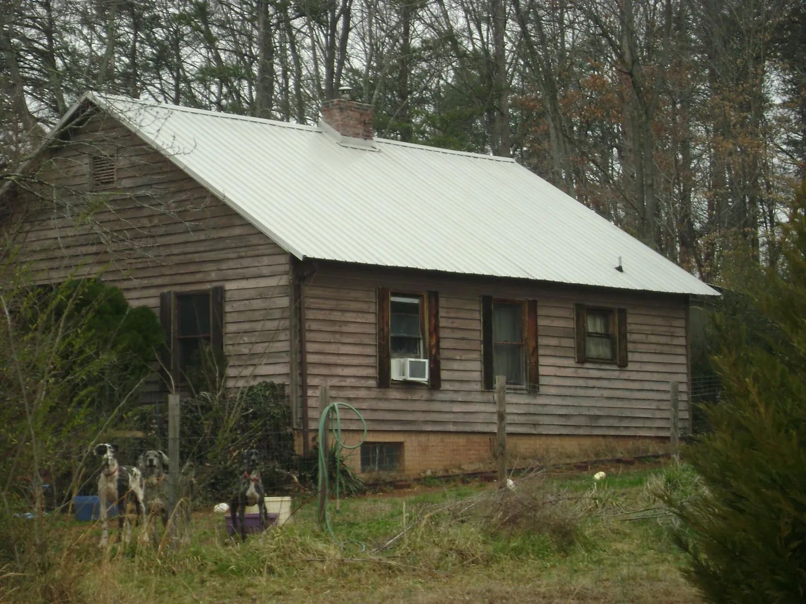 White metal roof on an old wood sided farmhouse, from a Metal Roof Installation job in Terrell